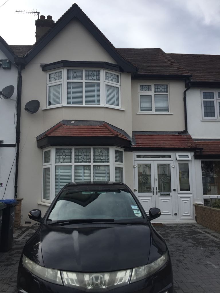 A traditional home exterior with bay windows and a light facade.