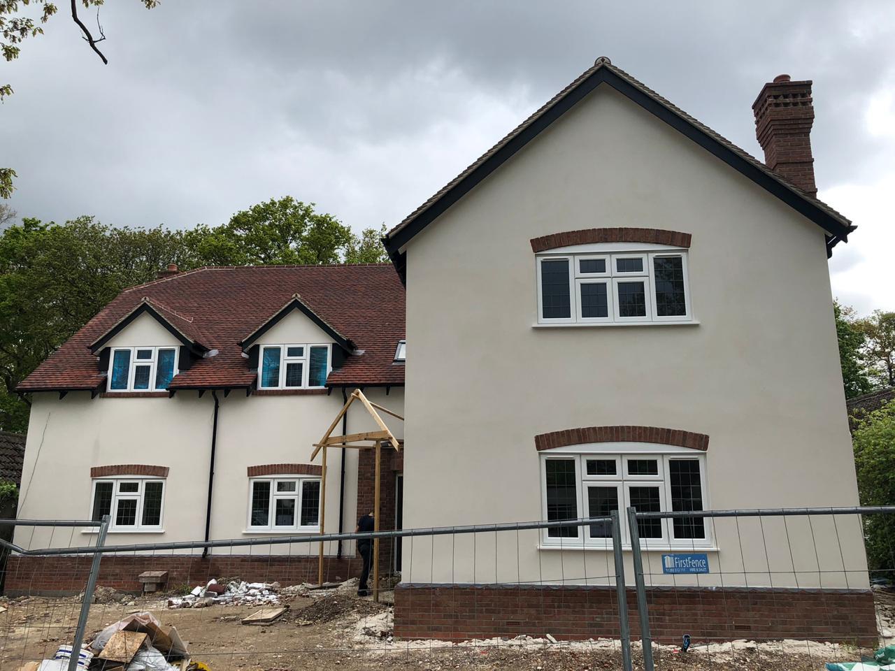 Rendered walls, brick detailing and dormer windows form the front of this detached home.