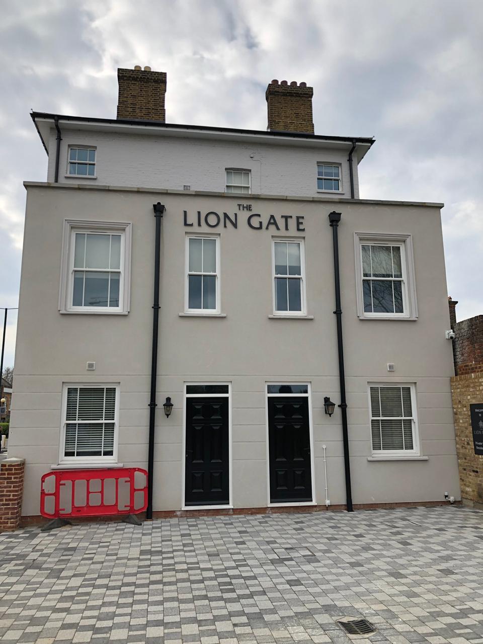 The entrance elevation, with a light render finish and contrasting dark doors.