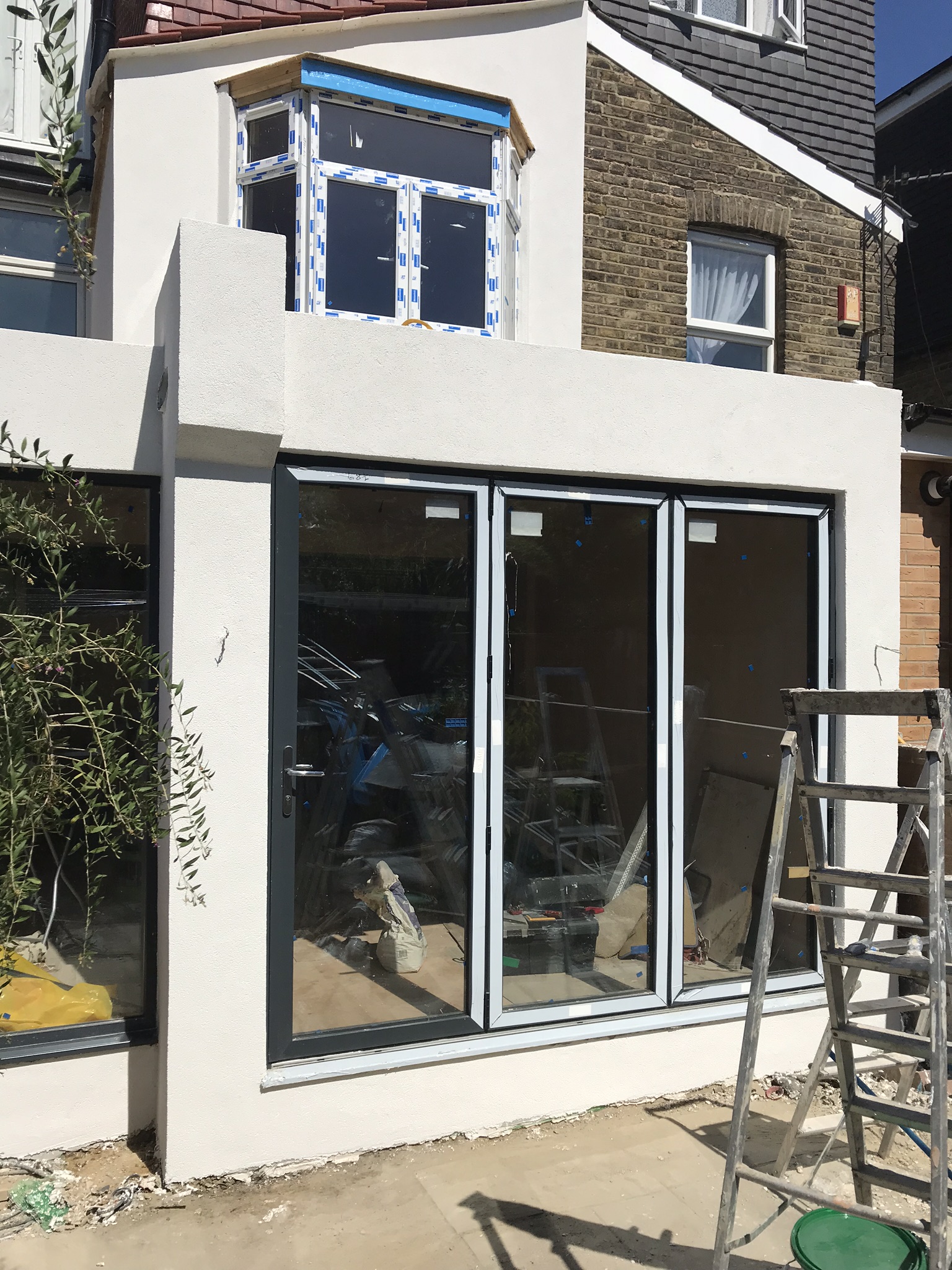 A new glazed opening and render finish, shown while construction is underway.