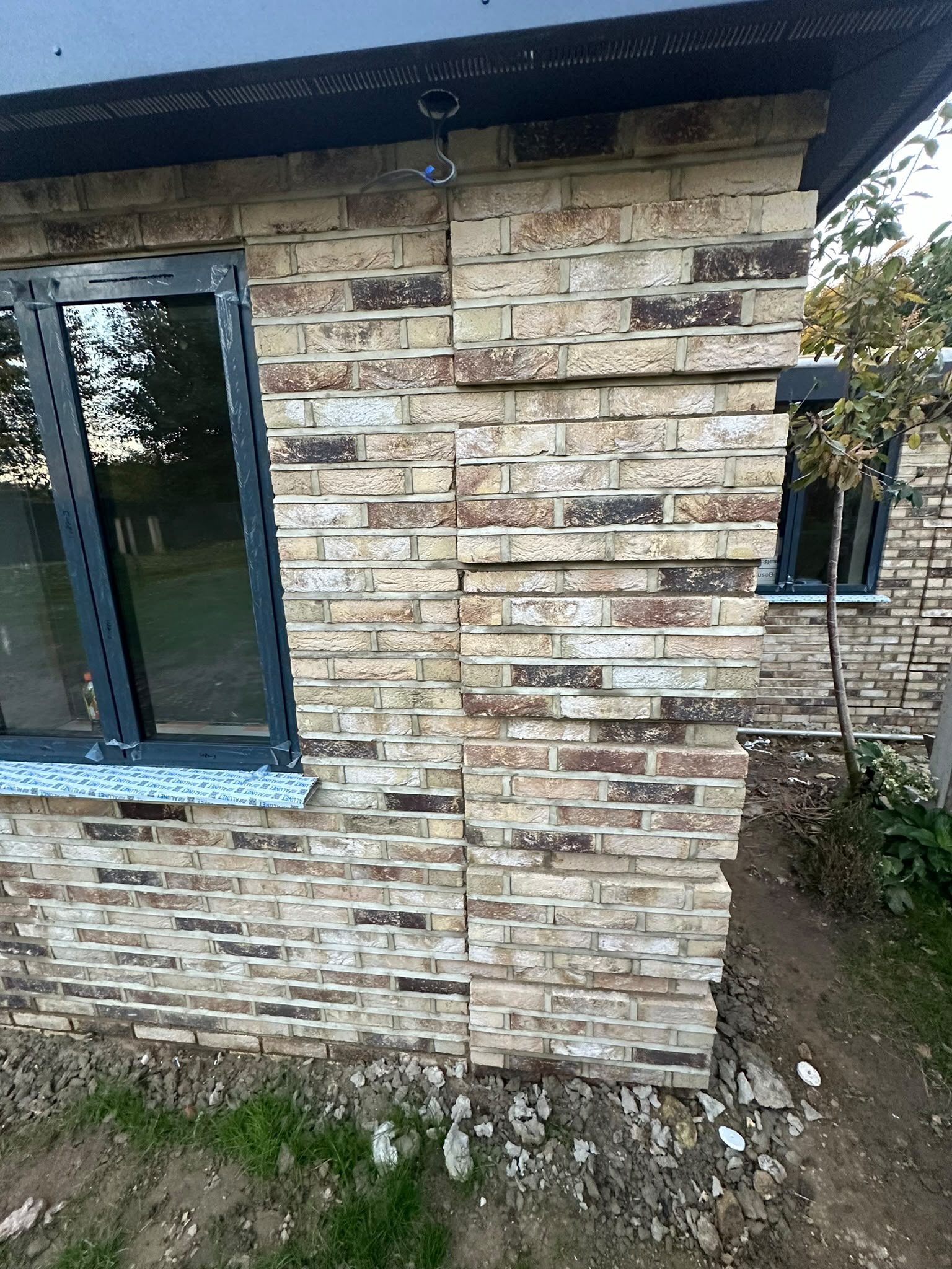 Brickwork and dark window frames at an exterior corner.