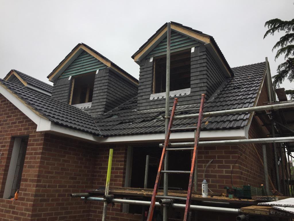Twin dormers and tiled roof work in progress.
