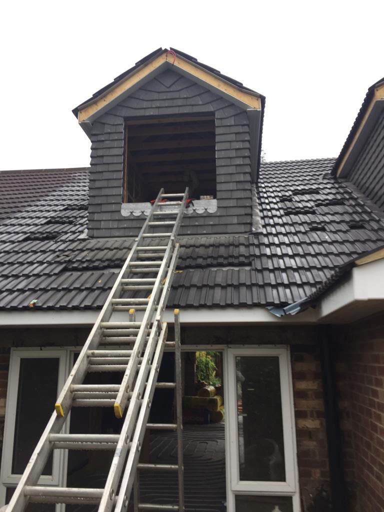 A tiled dormer roof during construction.